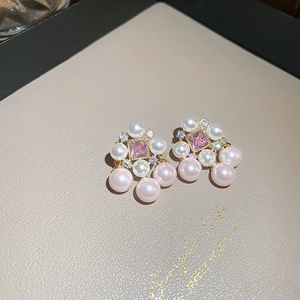 Macro view of pink crystal earrings with pearl tassels and gold plated silver studs