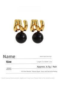 Detailed view of wave-shaped black agate earrings with gold-plated brass texture