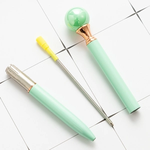 Elegante penna a sfera perlata verde menta con clip dorata mostrata smontata su griglia bianca