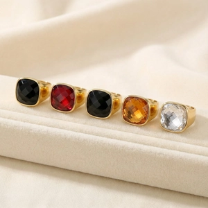 Detailed close-up of colorful faceted crystal gems on gold-plated stainless steel rings