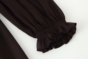 Close-up of elegant ruffled cuffs with elastic smocking on a dark chiffon midi dress