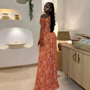 Detail of off-the-shoulder long sleeve dress with orange leaf pattern in modern interior