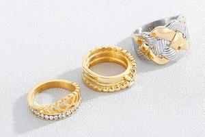 Detailed macro view of gold plated stainless steel crown rings and braided knot band
