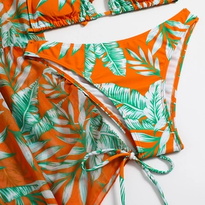 Flat lay detail of tropical palm leaf print bikini set with matching mesh cover-up