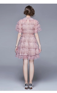 Detail of pink tiered lace dress back with ruffled edges and sleek zipper closure