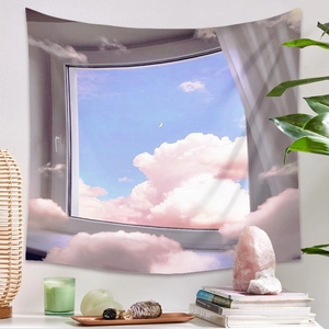 Détail d'une tapisserie bohème avec des nuages roses de rêve et la lune sur mur blanc