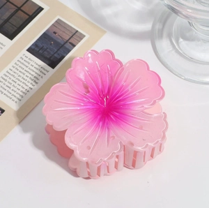 Detailed view of the pink gradient plumeria hair claw clip with smooth resin texture