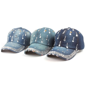 Dettaglio di tre cappellini in denim con strass e ciondoli a goccia in cristallo lucido