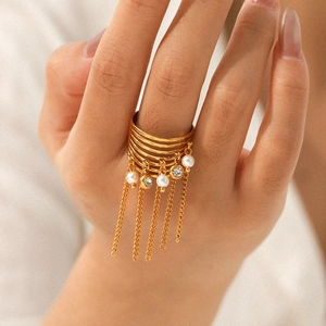 Gold multi-layer chain tassel ring with pearls and zircons on woman's hand