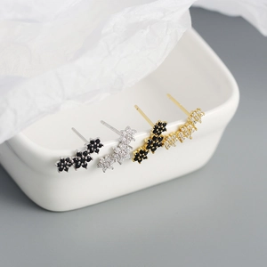 Detail view of four pairs of s925 silver flower stud earrings in gold and silver finish