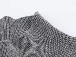 Detailed close-up of grey ribbed knit turtleneck collar showing soft texture and fine fabric