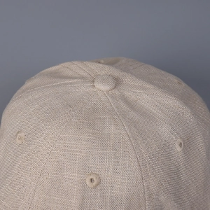 Detailed close-up of breathable linen baseball cap top with stitched eyelets and button