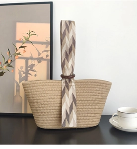 Detail of beige cotton rope hand-woven bag with wooden ring handle and chevron webbing