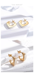 Détail macro de boucles d'oreilles C dorées avec émail blanc sur fond de pierre