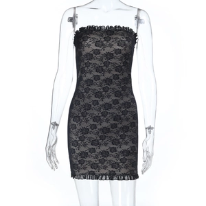 Détail d'une robe en dentelle noire avec bordures à volants et texture moulante sexy