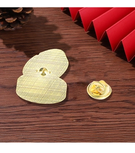 Detailed macro view of gold metal pin base with butterfly clutch back on wooden table