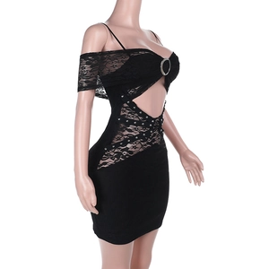 Dettaglio dell'abito in pizzo nero con anelli metallici e texture con intagli laterali