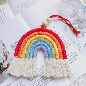 Detail of hand-woven rainbow wall hanging with white tassels and wood beads