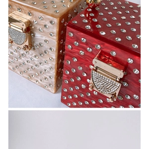 Close-up of champagne and red acrylic evening bags with marble texture and rhinestones
