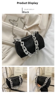 Close-up of black cylindrical rhinestone evening bag with silver chain detail