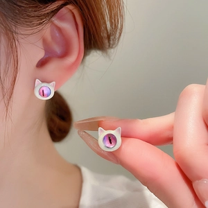 Detail view of cute cat stud earrings with white enamel and pink cat eye stone