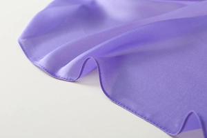 Detailaufnahme des violetten Satinschals mit weicher Textur und feiner Kantenverarbeitung
