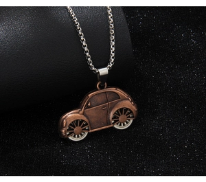 Close-up of vintage bronze beetle car pendant on silver box chain necklace