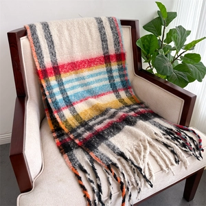 Detailed texture of thick plaid scarf with colorful fringe on a cozy wooden chair
