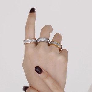 Three-tone Roman numeral rings in gold silver and rose gold worn on model hand