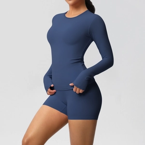 Detail view of navy blue long sleeve yoga top and high waist shorts with matte texture
