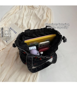 Spacious interior of black denim bucket bag showing cherry embroidery and daily essentials
