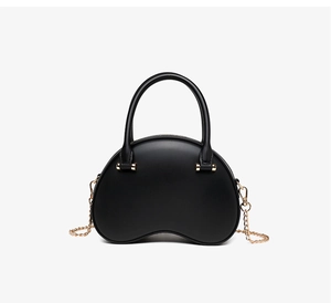 Detail of black kidney-shaped jelly bag featuring smooth texture and gold chain strap