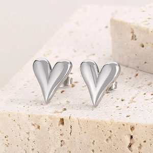 Polished silver heart stud earrings in minimalist stainless steel for women on stone base