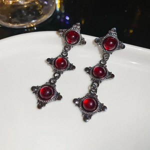 Close-up of gothic style red resin stones in vintage metal frame earrings set