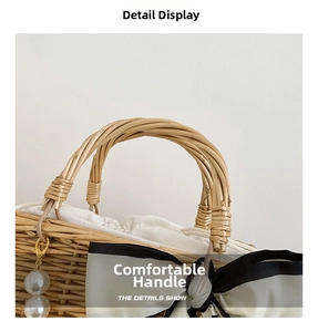 Detail of woven straw handbag featuring a round rattan handle and elegant pearl bow accent