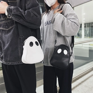 Detail view of cute cartoon ghost crossbody bags in black and white on models