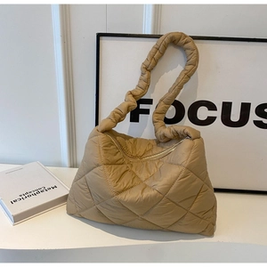 Detailed macro view of khaki quilted puffer shoulder bag with soft diamond stitching textures