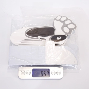 Weight measurement of large Halloween ghost stickers on a digital scale showing 65.1 grams