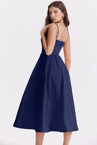 Detail of elegant backless navy blue midi dress with thin straps and draped fabric