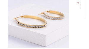 Detail of 18K gold-plated oval hoop earrings with sparkling pavé crystals
