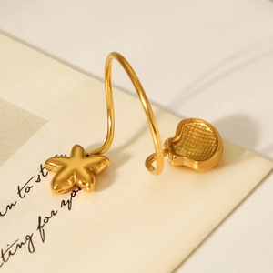 Detail of 18K gold starfish and shell charms on a polished stainless steel ring