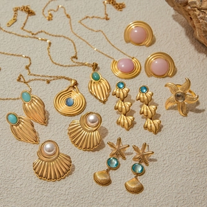 Gold-tone ocean theme jewelry set with starfish and seashell charms on beige background