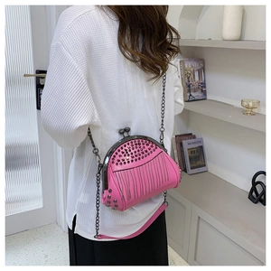 Detail der rosa Abendtasche mit Nietendesign und Metallkettenriemen in der Anwendung