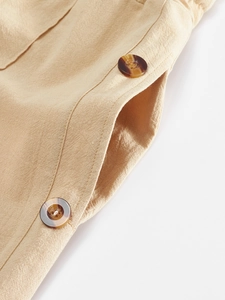 Macro detail of breathable linen pants showing tortoise shell buttons and side pocket texture