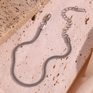Detail showing 18K engraved tag and lobster clasp on silver stainless steel chain