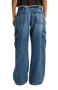 Detail of large rear pockets and washed texture on wide-leg cargo denim jeans