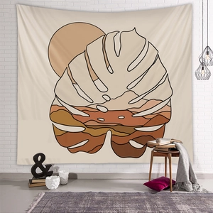 Detail view of Boho wall tapestry with abstract monstera leaf and sun landscape