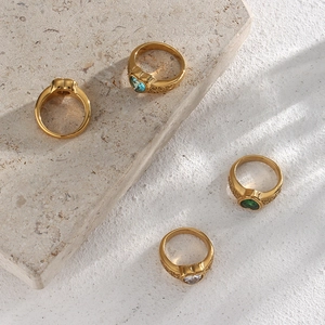 Gold rings with heart-shaped zircon stones and vintage engraving on marble texture