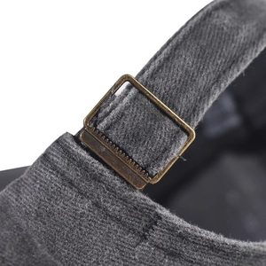 Detail of vintage bronze metal adjustment buckle on washed cotton baseball cap