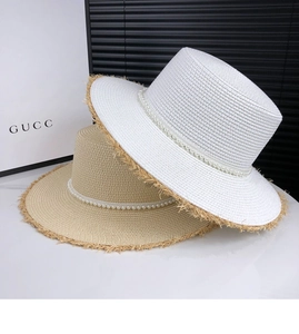 Detail of French straw hats with pearl embellishments and fringe edges in white and beige